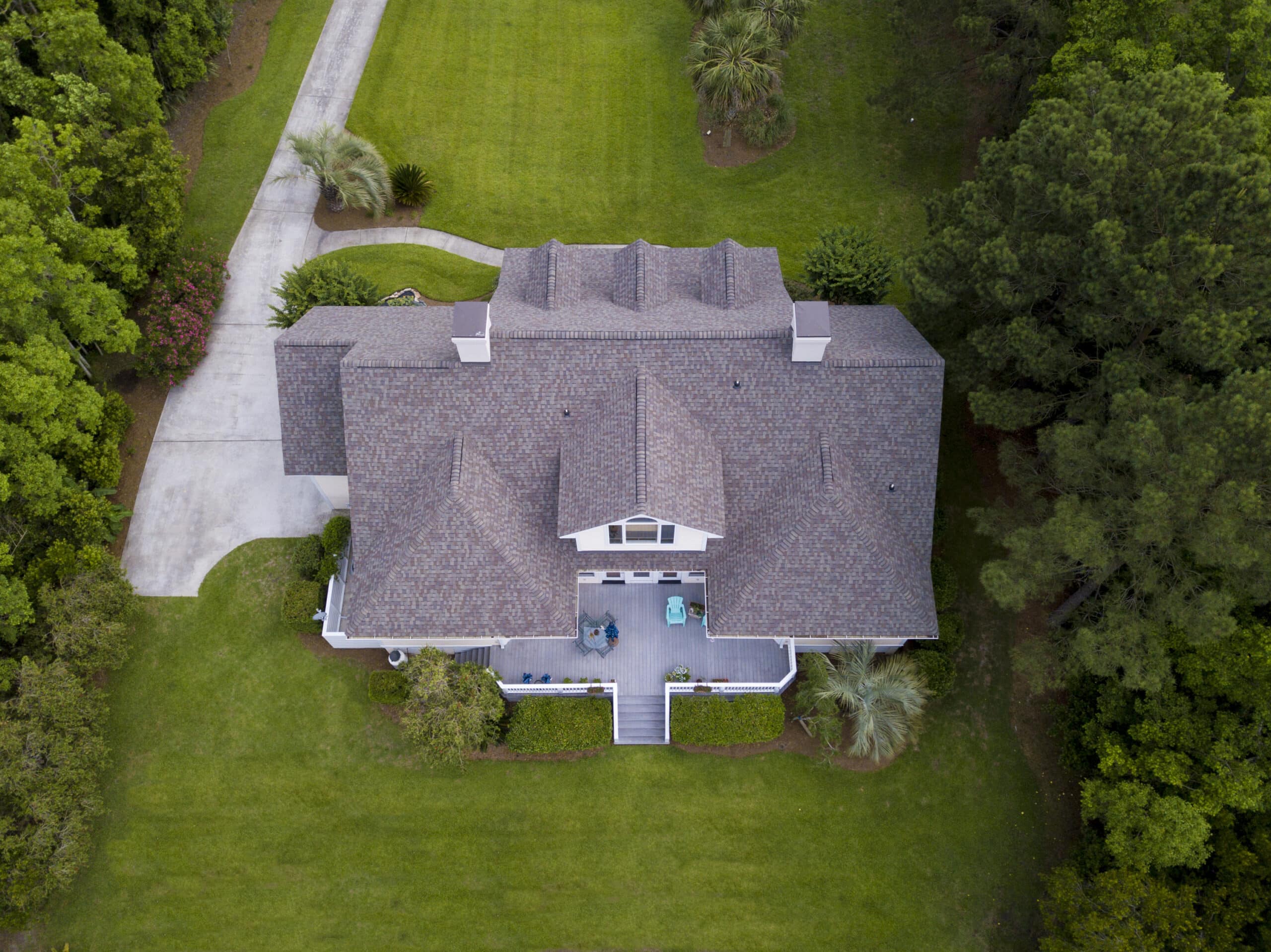 an aerial view of a house in a wooded area.